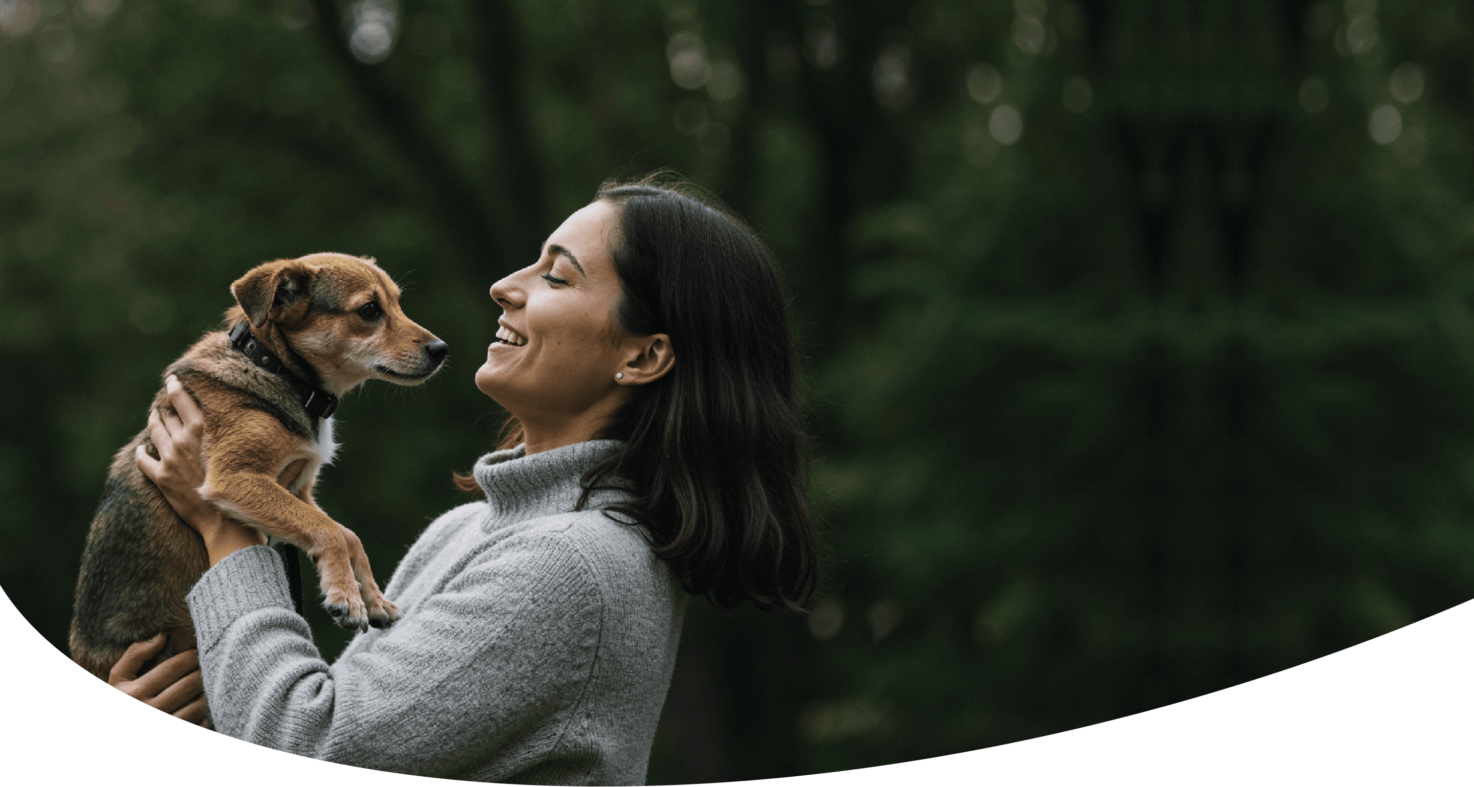 A woman smiling and hugging a small brown dog, inside a heart-shaped outline.